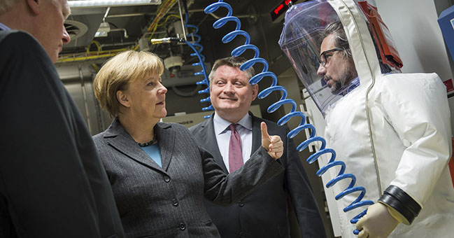 Bundeskanzlerin Angela Merkel lässt sich beim Besuch eines S4-Hochsicherheitslabors im Robert-Koch-Institut das neue Labor erklären.