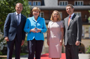 Bundeskanzlerin Angela Merkel und ihr Ehemann Joachim Sauer (r.) begrüßen den Präsidenten des Europäischen Rates, Donald Tusk, und dessen Ehefrau Małgorzata Tusk (2.v.r.) vor Schloss Elmau.