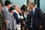 Der US-amerikanische Präsident Barack Obama wird am 07.06.2015 auf dem Flughafen München bei seiner Ankunft von Mitgliedern einer Trachtengruppe begrüßt.