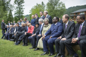 Die G7 sitzen zusammen mit den Outreach-Gästen zum Familienfoto auf einer Bank.