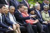 Großbritanniens Premierminister David Cameron unterhält sich während des Familienfotos der G7 mit den Outreach-Gästen mit Bundeskanzlerin Angela Merkel.