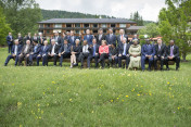 Die G7 sitzen zusammen mit den Outreach-Gästen zum Familienfoto auf einer Bank.