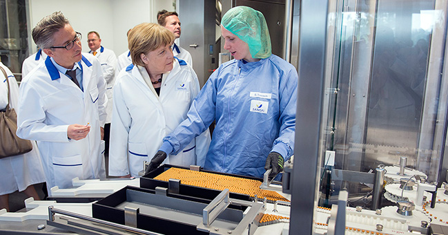 Chancellor Angela Merkel at the cleaning station during her guided tour of the Sanofi plant