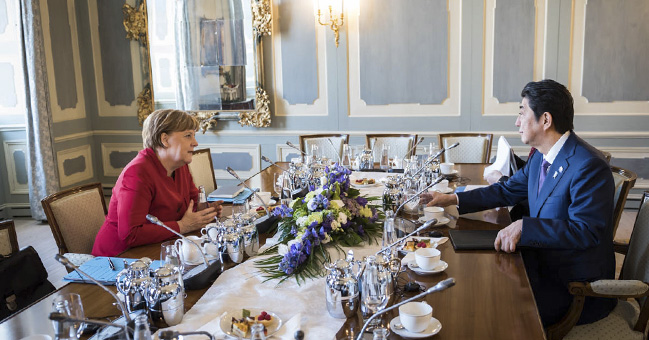 Chancellor Angela Merkel talking to Japan's Prime Minister Shinzo Abe