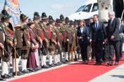 British Prime Minister David Cameron is greeted at Munich airport on 7 June 2015 by Bavarian Premier Horst Seehofer and a group of "Gebirgsschützen"