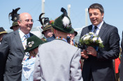 Italian Prime Minister Matteo Renzi is greeted at Munich airport on 7 June 2015 by children wearing traditional costume