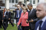 German Chancellor Angela Merkel talks with US President Barack Obama on the way to the family photo of the G7 with the Outreach guests