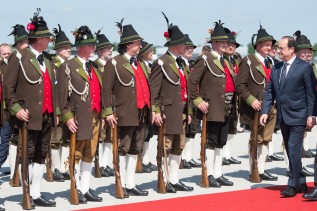 French President François Hollande is greeted at Munich airport on 7 June 2015 by a group of Bavarian "Gebirgsschützen"