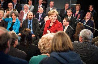 Chancellor Angela Merkel surrounded by interested ciitzens during the discussion